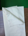 Organic pillowcases made from 100% cotton with a smooth finish, displayed on a wooden surface.