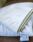 Organic cotton pillowcases on a bed, 230-thread count, GOTS certified.