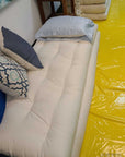 Cotton and wool shikibuton displayed on floor with cushions, showcasing natural handcrafted design.
