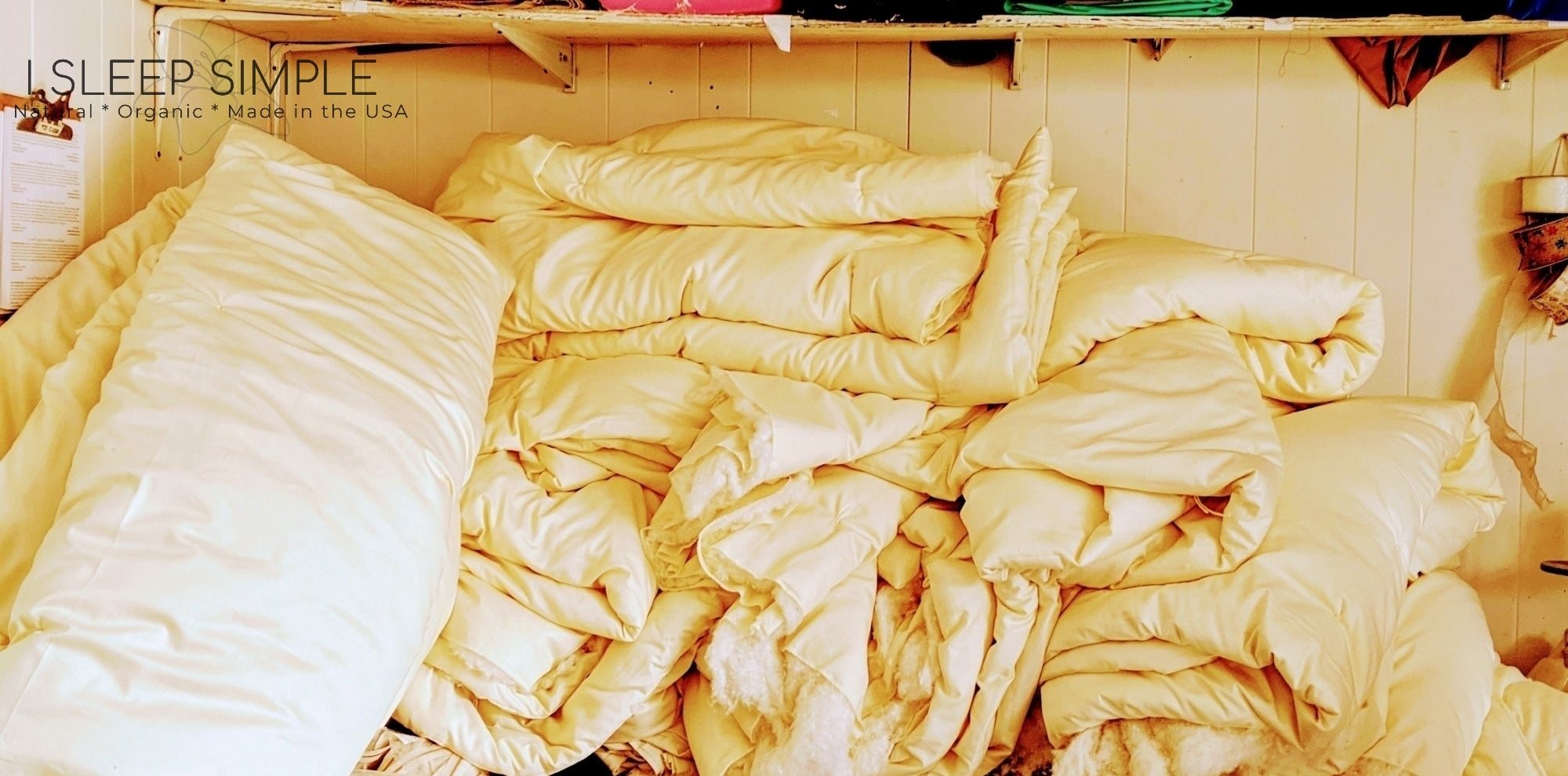 Stack of handmade organic cotton duvets in a cozy setting, featuring sustainable, eco-friendly materials.