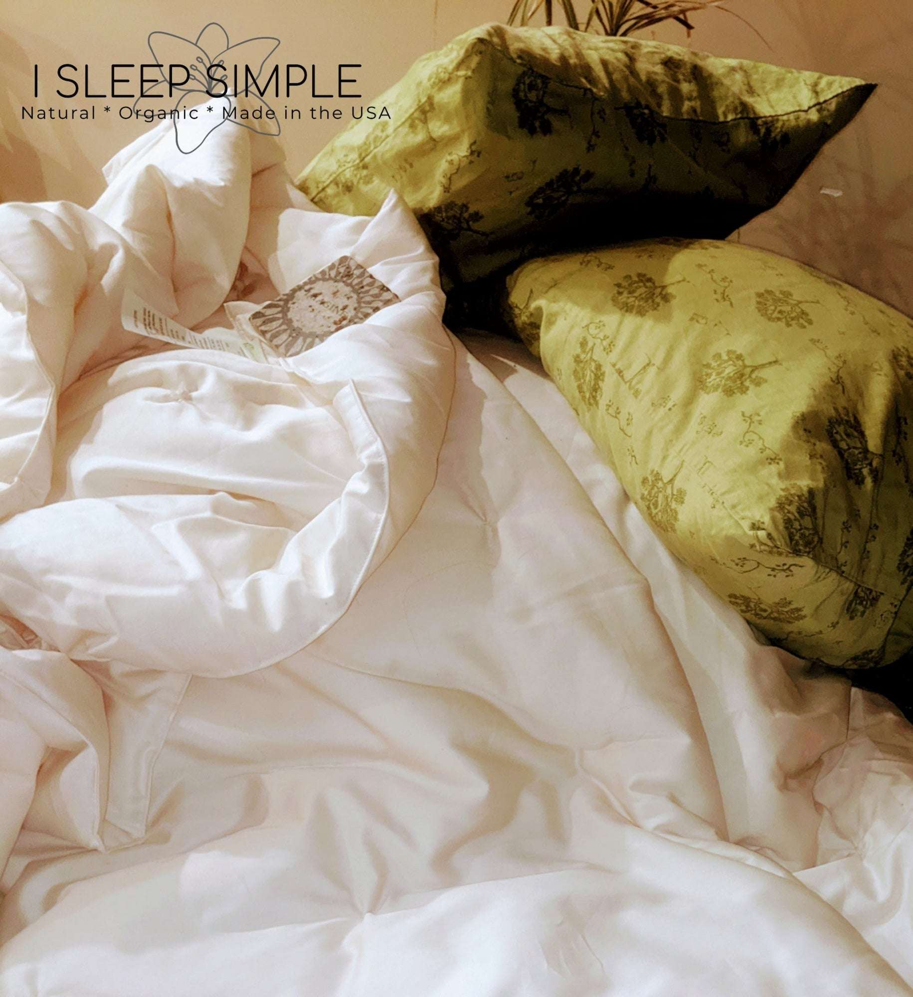 Organic cotton duvet on a bed with floral pillows, made in the USA.