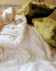 Organic cotton duvet on a bed with floral pillows, made in the USA.