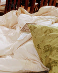 Washable wool duvet on a wooden chair, featuring cozy, eco-friendly merino wool.