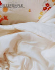 Organic cotton duvet on a floral bedspread, showcasing soft, eco-friendly comfort.