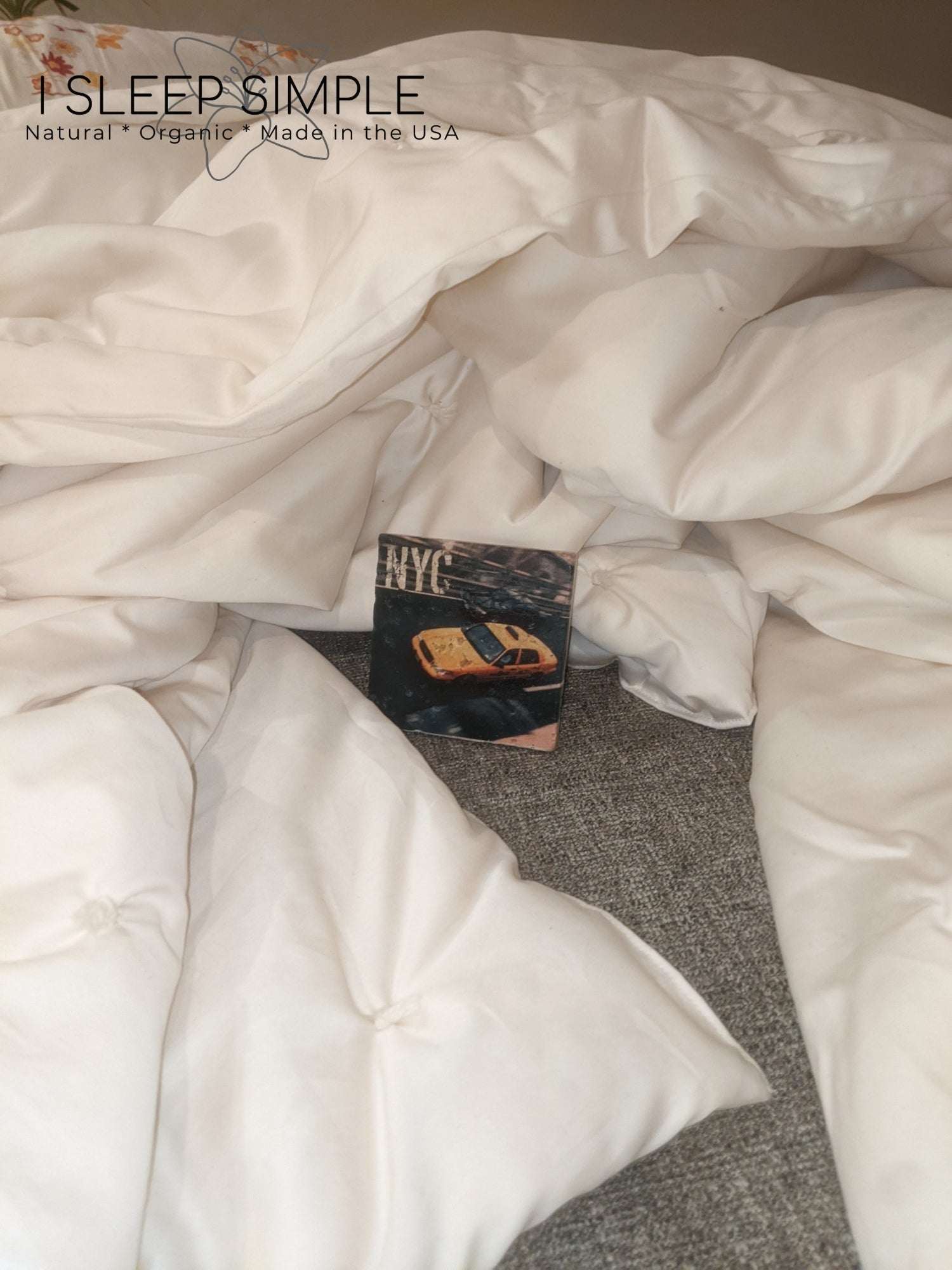 Handmade wool duvet made from New Zealand wool, eco-friendly and hypoallergenic, shown draped on a bed.