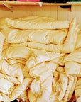 Stack of handmade organic cotton duvets in a cozy setting, featuring sustainable, eco-friendly materials.