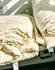 Handmade organic cotton duvets stacked, showcasing eco-friendly, breathable comfort from I Sleep Simple.