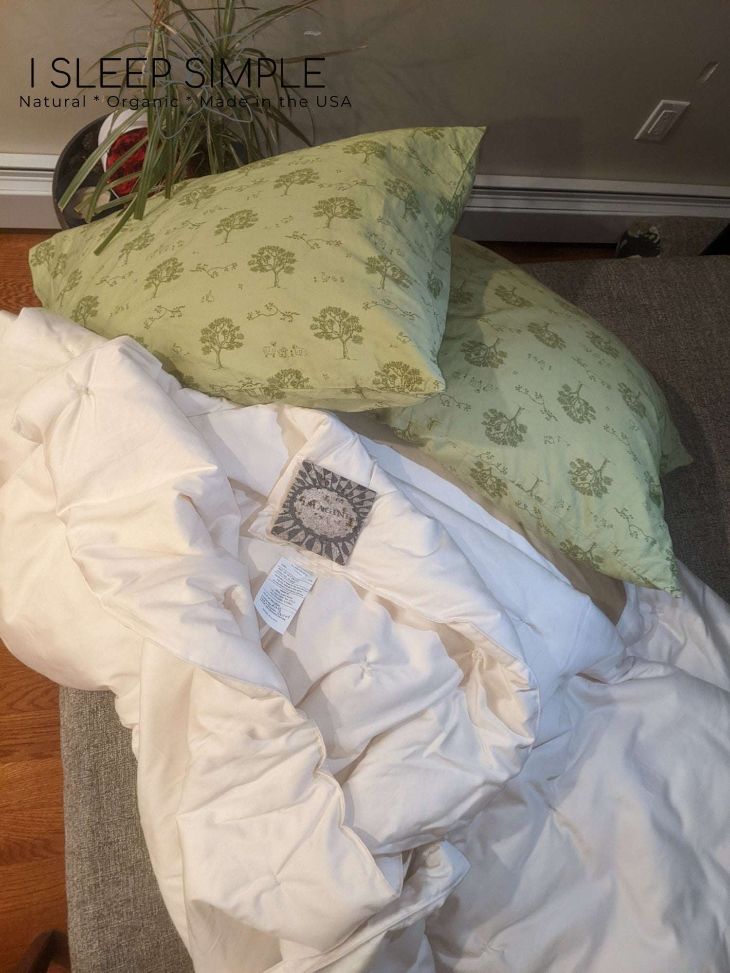 Handmade wool duvet with green pillows, eco-conscious USA-made bedding.