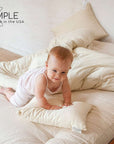 Baby on bed with I Sleep Simple washable wool duvet.