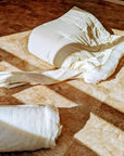 Handmade wool duvet on wooden floor, showcasing natural fibers and eco-conscious craft.