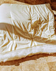 Handmade wool duvet on tiled floor, showcasing premium eco-friendly bedding.