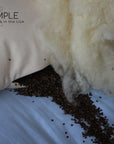 Buckwheat and wool pillow with natural organic fill on a blue background.
