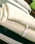 Cotton mattress topper on bed, showcasing its plushness and organic cotton material.