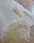Wool batting roll made of 100% virgin sheep's wool, un-dyed and untreated, ideal for insulation in pillows, quilts, and cushions.
