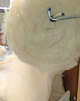 Virgin wool batting roll on a holder, natural and untreated, ideal for insulation and crafting.