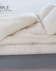 Wool mattress topper on bed for natural comfort and support, handmade in the USA.