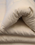 Wool mattress topper folded with I Sleep Simple logo, handmade in the USA.