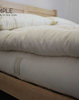 Organic cotton mattress topper on a bed for natural plush comfort.