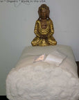 Organic cotton and wool futon mattress roll with Buddha statue.