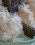 Kapok Fiber loose natural filling in wooden box, plant-based vegan eco-friendly material for pillows and cushions.