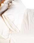 Organic cotton pillowcases on a bed, soft and smooth, made in the USA.