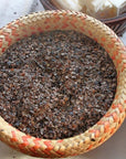 Organic buckwheat hulls in a woven basket, ideal for pillows and cushions, promoting comfort and airflow.