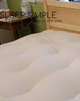 GOTS certified organic cotton and wool futon mattress on wooden bed frame.