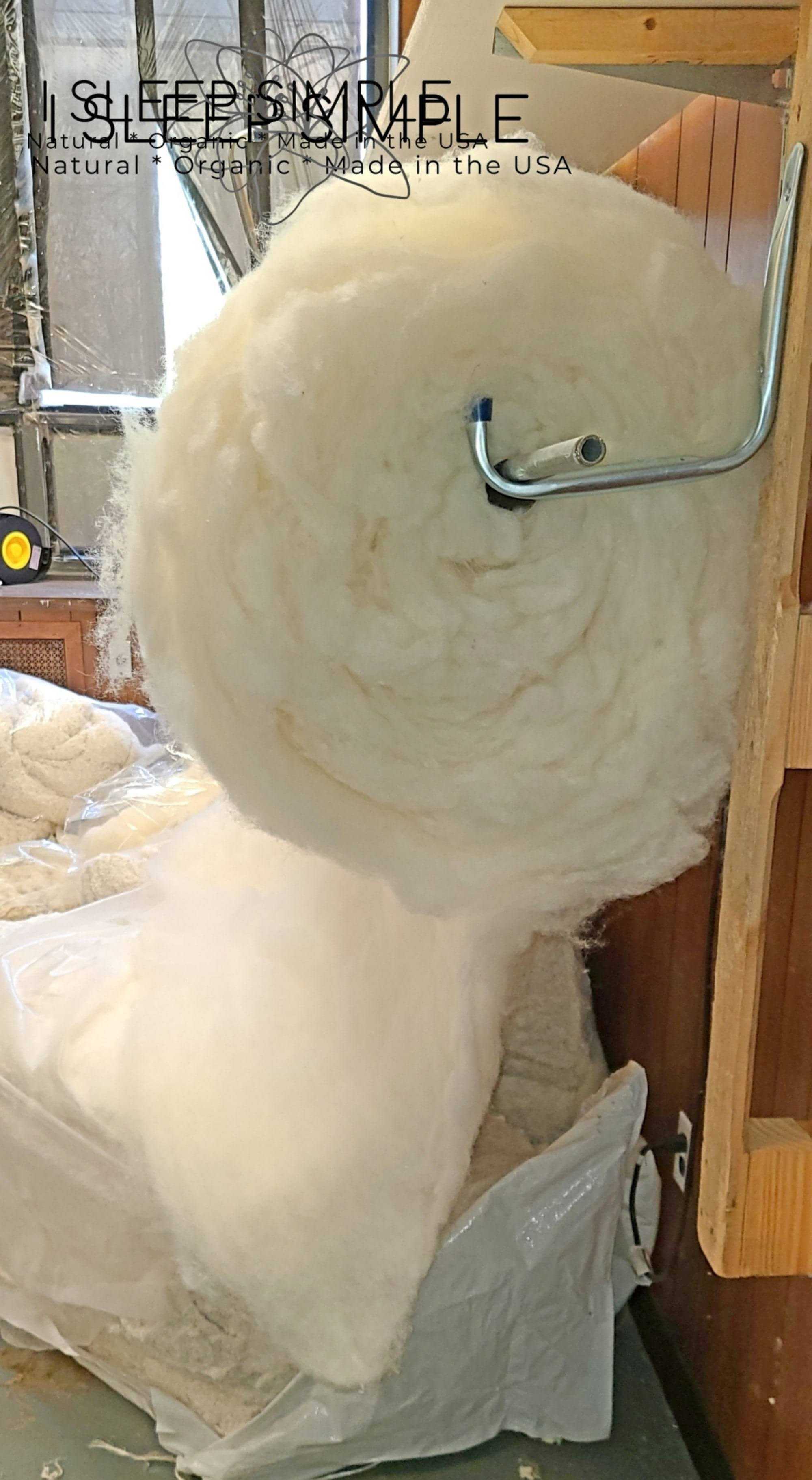 Virgin wool batting roll on a holder, natural and untreated, ideal for insulation and crafting.