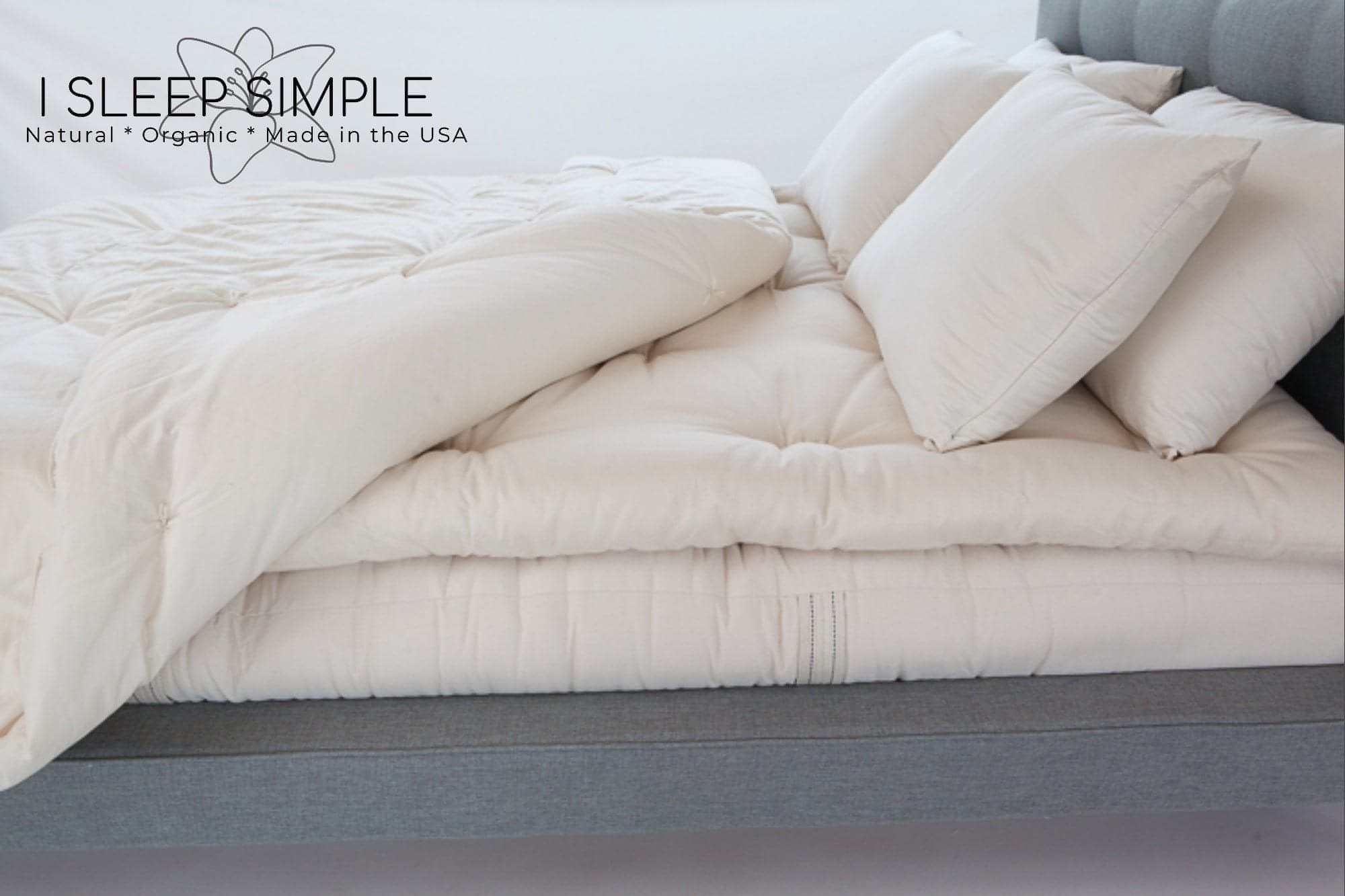 Wool mattress topper on bed for natural comfort and support, handmade in the USA.