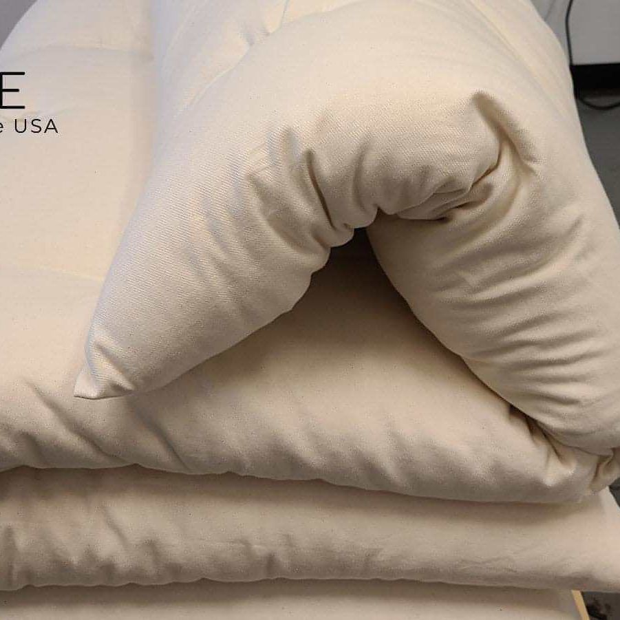 Wool mattress topper folded with I Sleep Simple logo, handmade in the USA.