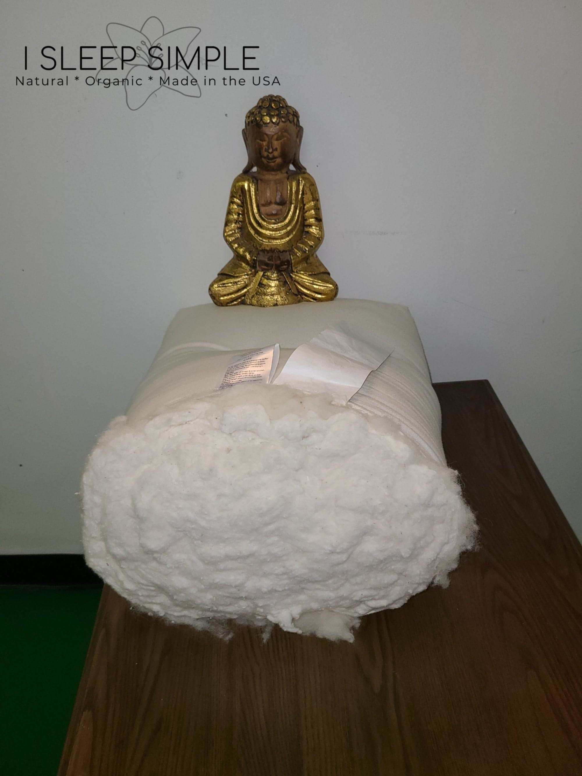 Firm organic cotton and wool futon mattress with a decorative statue on top, GOTS certified, natural and handcrafted.