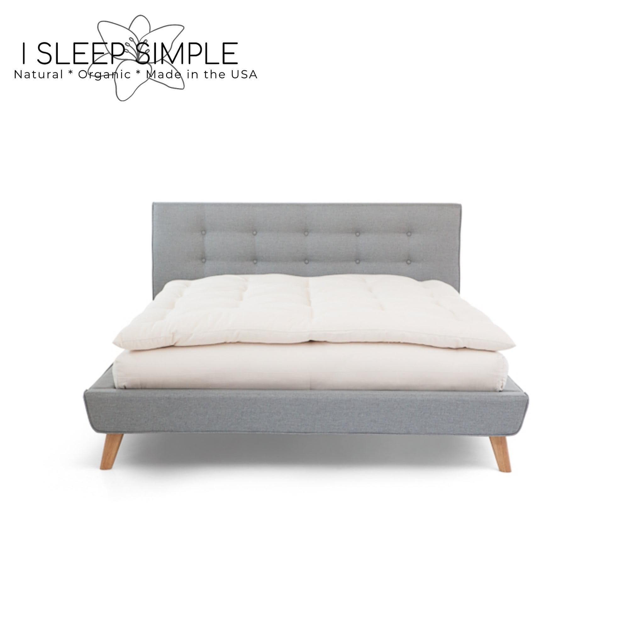 GOTS Certified Organic Topper made of cotton on gray bed frame.