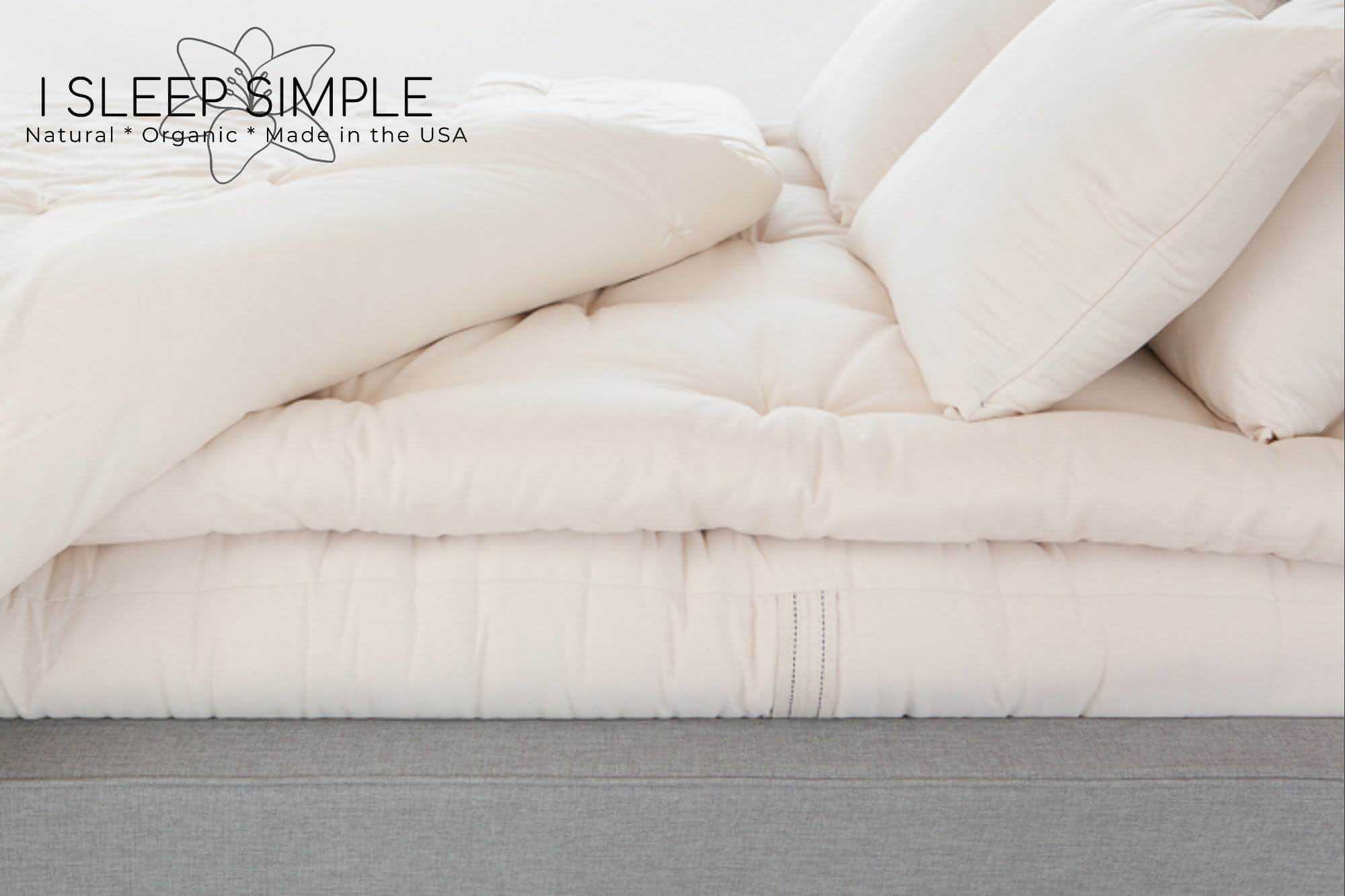 Organic cotton mattress topper on bed, soft and plush bedding, made in the USA.