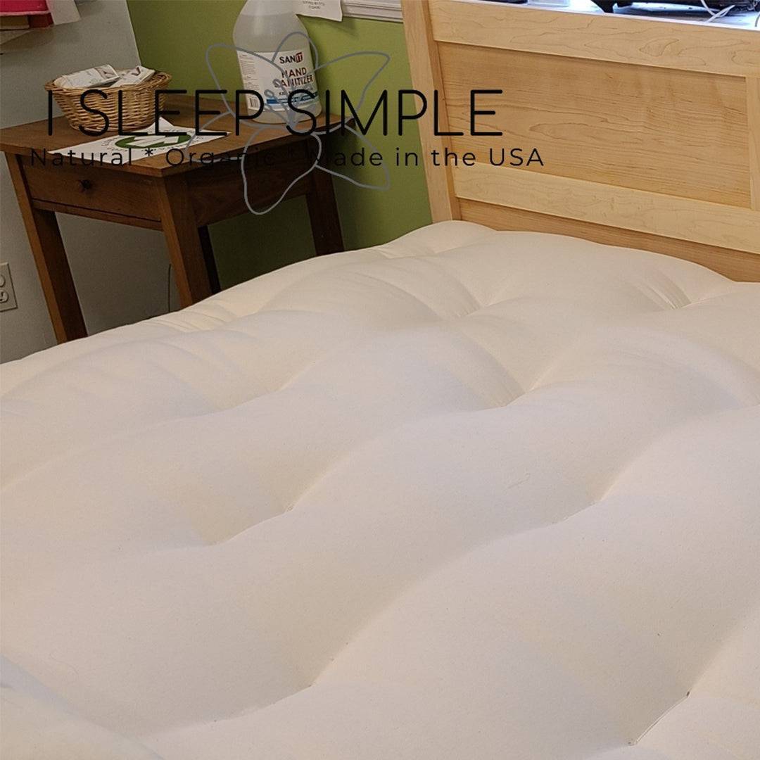 GOTS certified organic cotton and wool futon mattress on wooden bed frame.